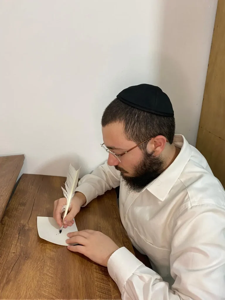 שעיה, מייסד SHAYA, כותב על קלף בעבודת יד